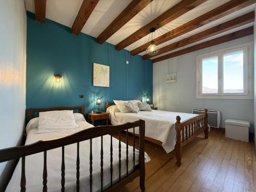 two beds in a room with blue walls at Aguerrea in Macaye