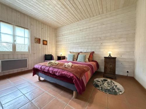 una camera da letto con un letto e una parete in legno di Garate a Espelette