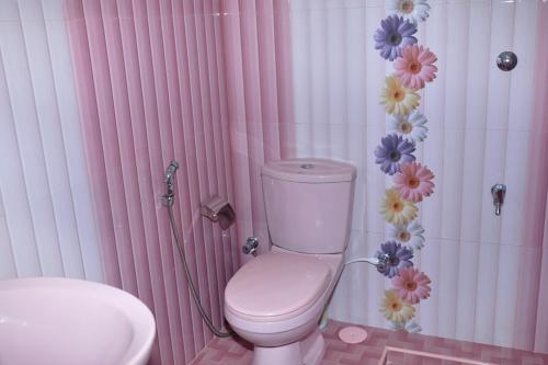 y baño blanco y rosa con aseo y lavamanos. en Hotel Pearl Gate, en Chilaw
