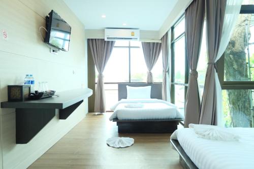 a hotel room with two beds and a window at A Plus Deluxe Hotel in Ko Lipe
