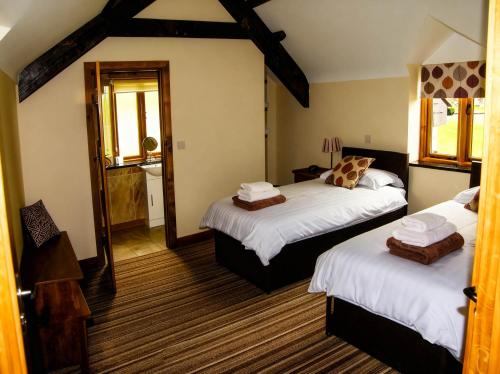 a bedroom with two beds and a mirror at Tyn Y Celyn Canol in Clocaenog