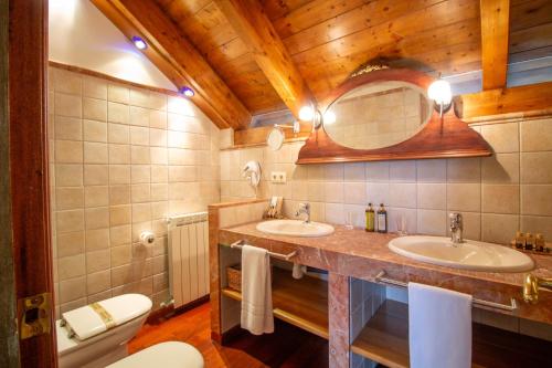 a bathroom with two sinks and a mirror at HOTEL EL Alboroque in Tramacastilla de Tena
