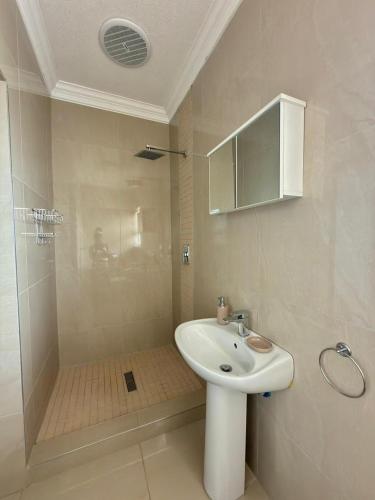a white bathroom with a sink and a shower at Oceanview Oasis in Freeland Park
