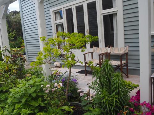 a porch with a table and chairs and flowers at Captain Eady's Lookout in Portobello
