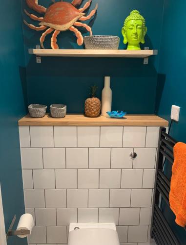 a bathroom with a green head on a shelf above a toilet at The Wendy House in Walton-on-the-Naze