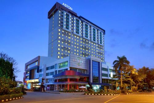 a tall building with a sign on top of it at Aston Solo Hotel in Solo