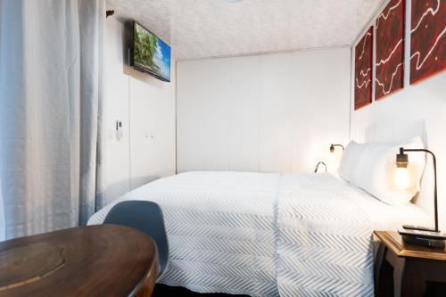 a small bedroom with a bed and a table at Pura Vida Rent in Nosara