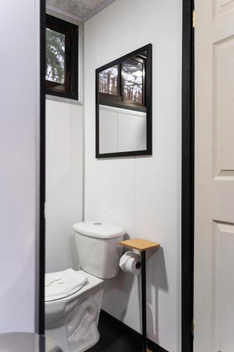 a white bathroom with a toilet and a window at Pura Vida Rent in Nosara