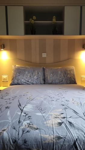 a bed with a blue comforter with birds on it at East Lothian Escape in Port Seton