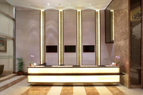 a lobby with a large white table and gold pillars at Aston Solo Hotel in Solo