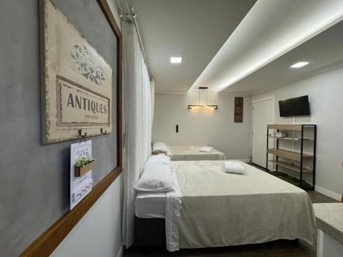 a hospital room with two beds and a tv at Suite Juede Platz - 02 - Centro de Pomerode in Pomerode