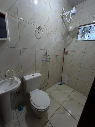 a bathroom with a toilet and a sink at Pousada Gaivota in Trindade