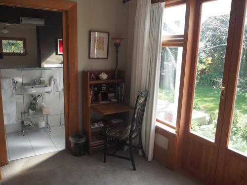 a bathroom with a sink and a desk next to a window at Captain Eady's Lookout in Portobello
