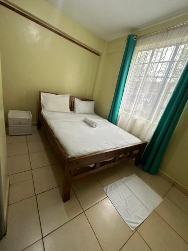 a bed in a room with a window at The O,S Homestay in Chuka