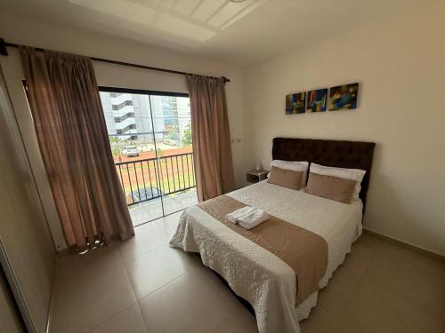 a bedroom with a bed and a large window at Nerea-Casa de Playa en Condominio Mar Adentro in Naranjalito