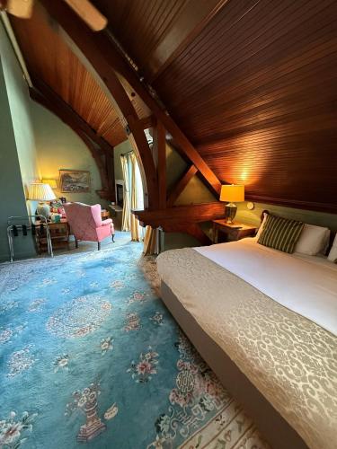 a bedroom with a bed and a chair in a room at Belfry Inn and Bistro in Sandwich