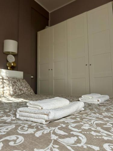 two white towels are sitting on a bed at La casetta triangolare in Bernalda