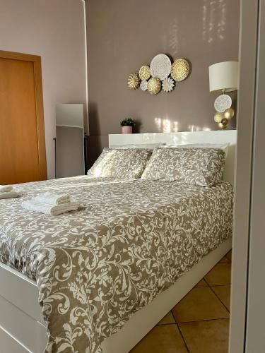 a bedroom with a large bed with a white headboard at La casetta triangolare in Bernalda
