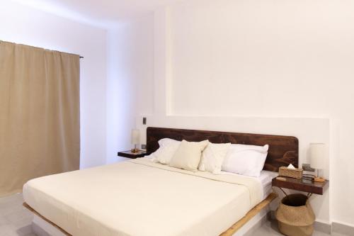 a white bedroom with a bed with white sheets and pillows at Casa Pola in Malucano