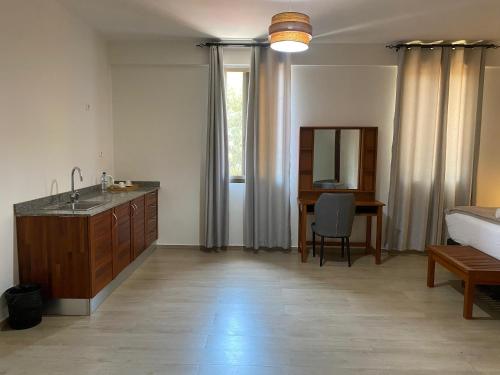 a bathroom with a sink and a desk in a room at Hotel Monte Verde in Beira