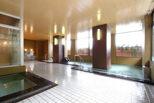un gran vestíbulo con suelo enfermo y ventanas en un edificio en Hotel Kinomezaka, en Minami Uonuma