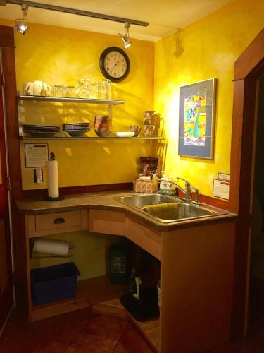a kitchen with a sink and a clock on the wall at Mistiso's Place Vacation Rentals in Nelson
