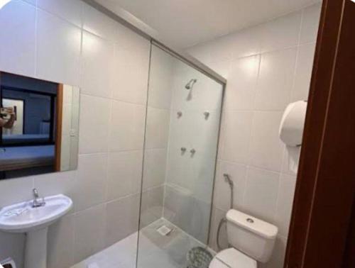 a bathroom with a shower and a toilet and a sink at Pousada Maré Alta in Maceió