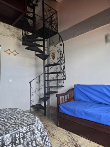 a bedroom with a spiral staircase next to a bed at PERÓ BEIRA MAR - Flat âncora - 203A in Cabo Frio