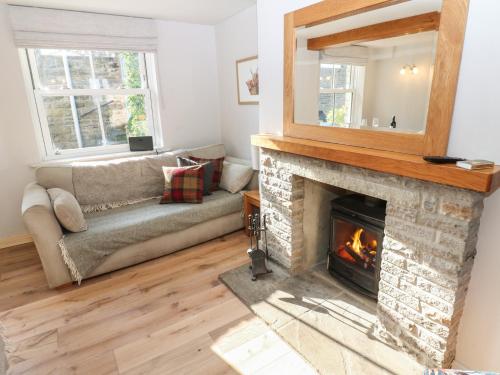 a living room with a fireplace and a mirror at Hillside View in Hawes