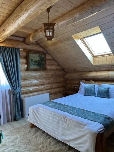 a bedroom with a bed in a log cabin at Pensiunea Sub Ursoi in Ieud