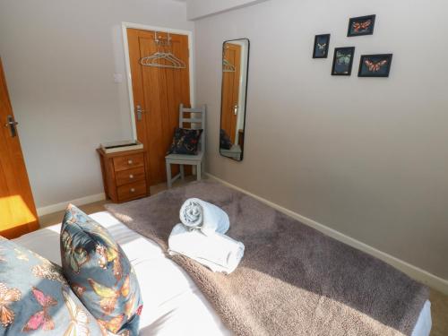a bedroom with a bed with a mirror and towels at Hillside View in Hawes