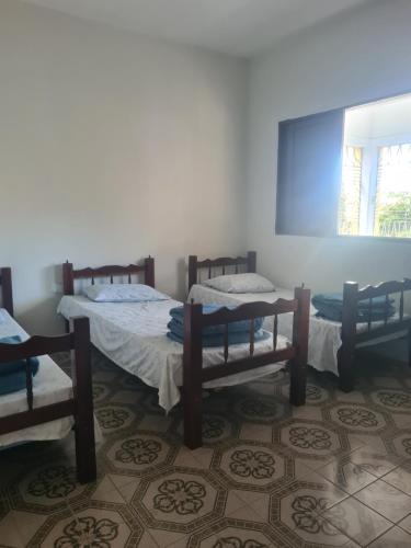 a room with three beds and a window at Casa do Lago Triunfo in Triunfo