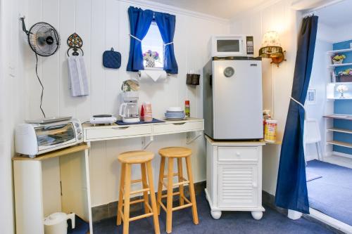 a kitchen with two stools and a refrigerator at Sun-Soaked Studio with Pool Access in Lake Worth! in Lake Worth