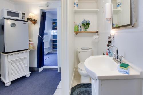 a bathroom with a toilet and a sink and a refrigerator at Sun-Soaked Studio with Pool Access in Lake Worth! in Lake Worth