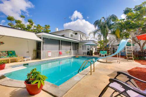 a swimming pool with a slide in front of a house at Sun-Soaked Studio with Pool Access in Lake Worth! in Lake Worth