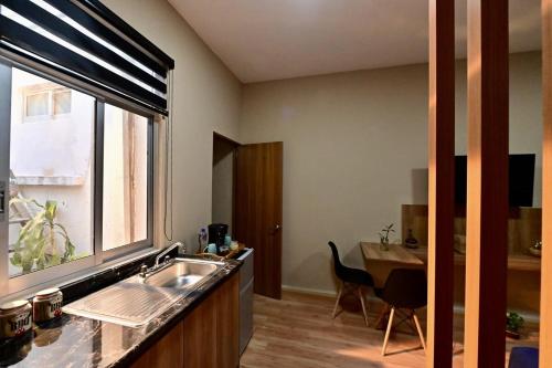 a kitchen with a sink and a table and a window at Loft centrico en Morelia in Morelia