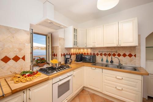 a kitchen with white cabinets and a sink at Oasi Milano in Furore