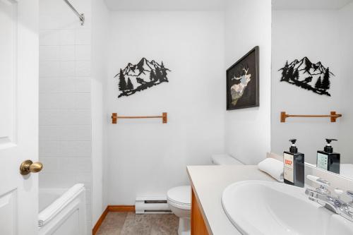 a bathroom with a white toilet and a sink at Hauts-bois Ski Inout 2brs Wpool Access 197-9 in Mont-Tremblant