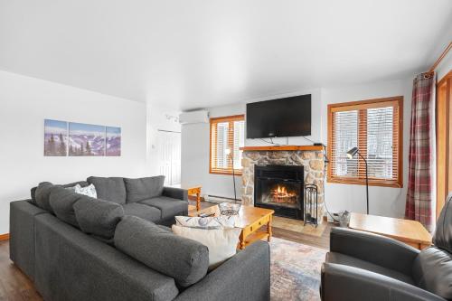 a living room with a couch and a fireplace at Hauts-bois Ski Inout 2brs Wpool Access 197-9 in Mont-Tremblant