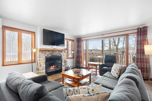 a living room with a couch and a fireplace at Hauts-bois Ski Inout 2brs Wpool Access 197-9 in Mont-Tremblant