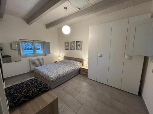 a bedroom with a bed and a window at Maison Cavallino in Lugo