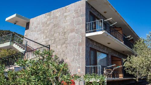 a building with balconies and stairs on it at Sivrice Sarnıç in Behramkale