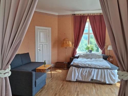 a bedroom with a bed and a couch and a window at Private floor in Molkom