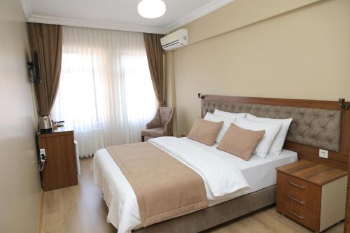 ein Schlafzimmer mit einem großen Bett und einem Fenster in der Unterkunft Ramparts Hotel in Istanbul