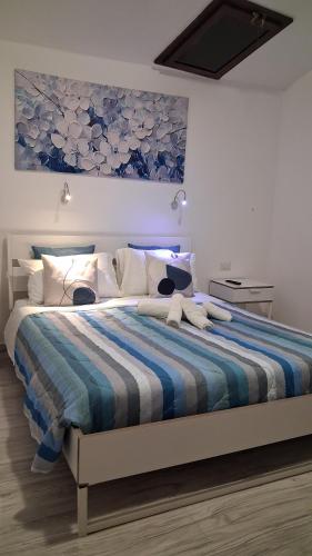 a bedroom with a bed with a blue and white comforter at Sa domu rubia in Iglesias