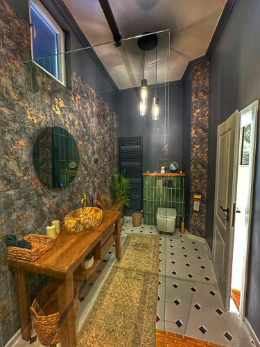 a bathroom with a wooden sink and a mirror at Euphoria Apartments in Beiuş