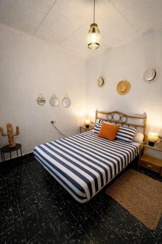a bedroom with a bed with a blue and white striped sheets at Casa caloret -Playa y centro a 2 min - 1ªPlanta in Vinarós