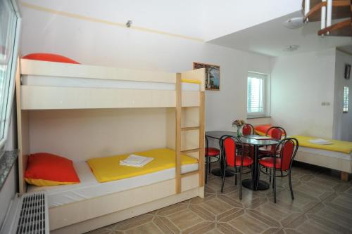 a room with bunk beds and a table with chairs at Golden Coast Villa Caska in Novalja