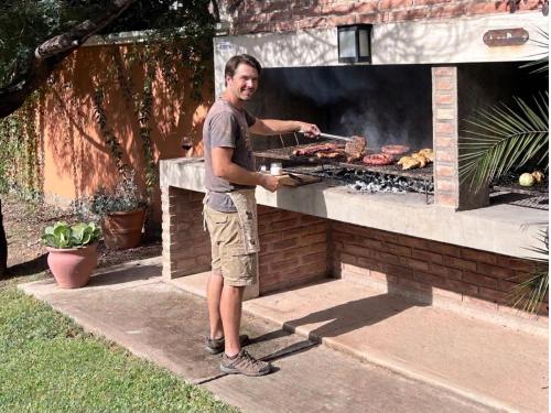a man standing next to a barbecue grill at Refugio - Suite privada con jardín y parrilla en Chilecito in Chilecito