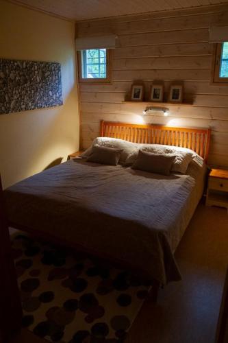 a bedroom with a large bed in a log cabin at Koliwood B in Kolinkylä